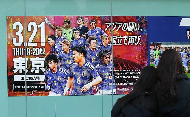 <yonhap photo-5471="">지난 21일 북한과 일본의 2026 북중미 월드컵 아시아 2차 예선 조별리그 3차전 경기가 열린 도쿄 국립경기장에 관련 포스터가 붙어 있다. 사진=연합뉴스</yonhap>
