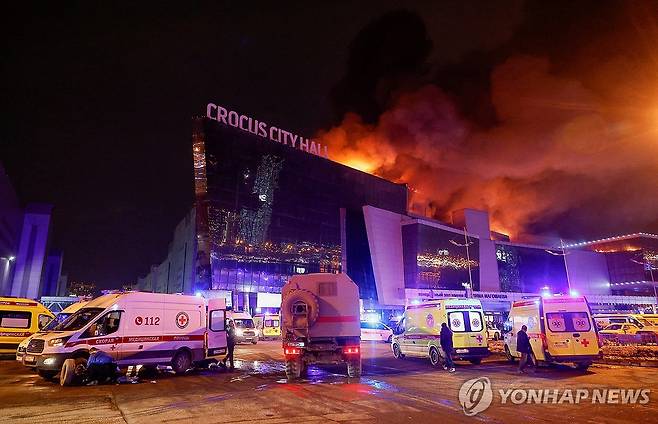 화염 치솟는 러시아 무차별 총격 사건 현장 (크라스노고르스크 로이터=연합뉴스) 22일(현지시간) 무차별 총격 사건이 벌어진 러시아 모스크바 외곽 대형 콘서트장에서 화염이 치솟고 있다. 외부에는 구급차가 부상자를 이송하기 위해 대기 중이다. 2024.3.23