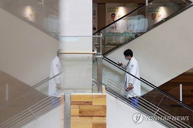 의대교수 사직·전공의 면허정지 D-1 (서울=연합뉴스) 임화영 기자 = 정부의 의대 정원에 반발한 전국 의대 교수들의 사직서 제출과 전공의 면허정지 처분을 하루 앞둔 24일 서울 시내의 한 대학병원에서 의료진이 이동하고 있다.
    전국 의대 교수 비상대책위원회는 25일부터 19개 대학별로 사직서를 제출하기로 결의했으며, 보건복지부는 업무개시명령에도 돌아오지 않은 전공의들의 면허를 내일부터 차례로 정지시킬 계획이다. 2024.3.24 hwayoung7@yna.co.kr