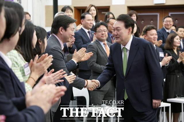 윤석열 대통령이 25일 경기 용인시청에서 '대한민국 신성장동력 허브, 용인특례시'를 주제로 열린 스물세 번째 국민과 함께하는 민생토론회에 입장하며 참석자들과 인사하고 있다. 윤 대통령은 "선거용 립서비스가 아니다. 지역의 작은 공약까지 다 챙겨서 100% 이행하겠다"고 밝혔다. /뉴시스