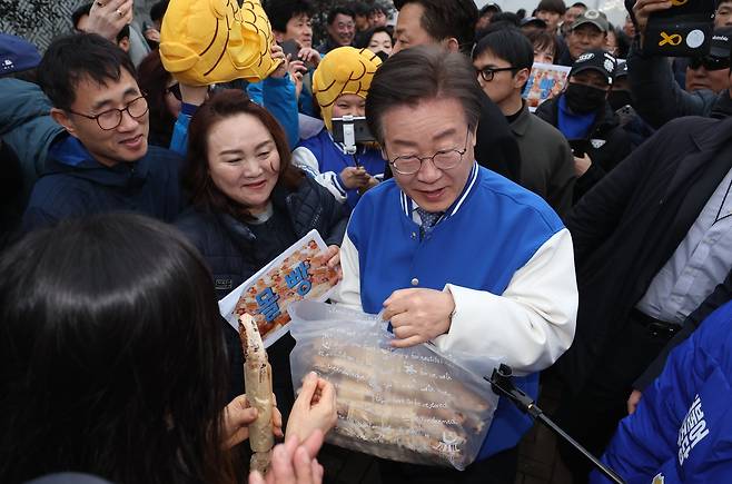 이재명 더불어민주당 상임공동선대위원장이 25일 거제 삼성중공업 입구에서 출근 인사를 하던 중 지지자로부터 빵을 선물받고 있다. 연합뉴스