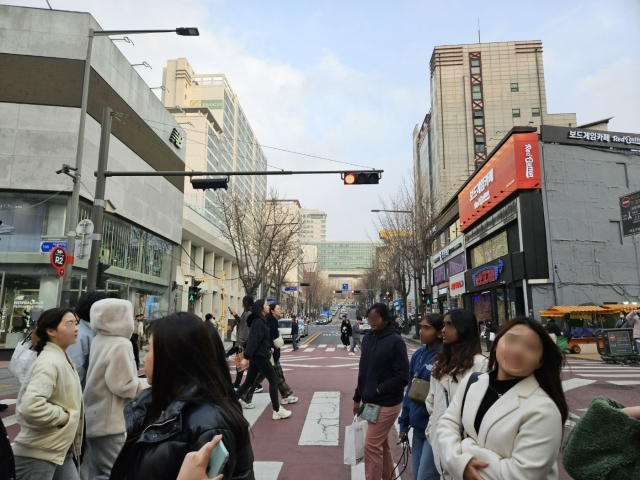 지난 19일 홍대 중심 상권인 '걷고싶은거리'(어울마당로) 횡단보도에서 홍대 정문을 향해 촬영한 사진. 홍대를 찾은 관광객들이 횡단보도를 지나고 있다. 이정헌 기자