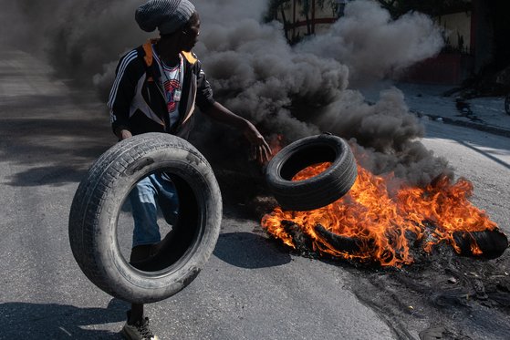 올해 들어 반정부 시위와 갱단의 무장 폭력으로 무정부 상태에 빠진 아이티 포르토프랭스에서 지난 12일 시위대가 타이어에 불을 붙이고 있다. EPA=연합뉴스