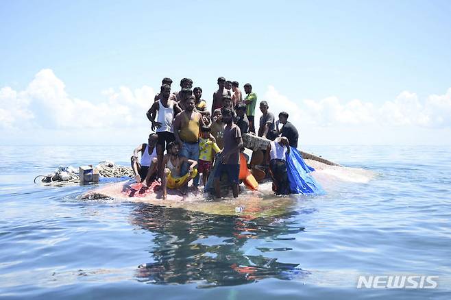 [서아체=AP/뉴시스] 지난  21일 인도네시아 서아체 해역에서 로힝야족 난민들이 전복된 목선 위에 모여 구조를 기다리고 있다. 인도양 안다만해 인근에서 로힝야족 익사자가 속출한다고 유엔은 말했다. 2024.03.21.