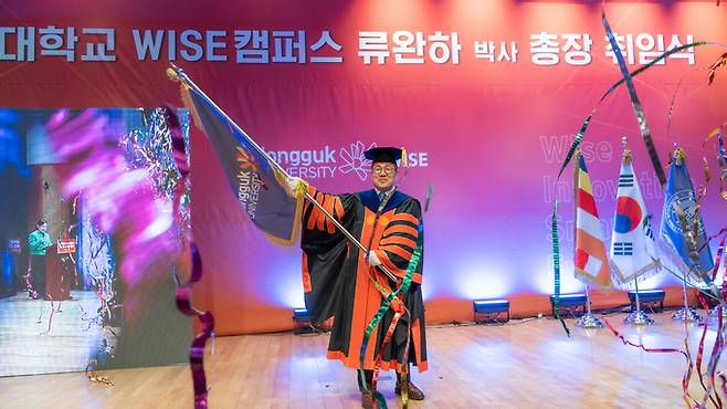 류완하 신임 동국대학교 WISE캠퍼스 총장이 취임식에서 교기를 흔들고 있다.