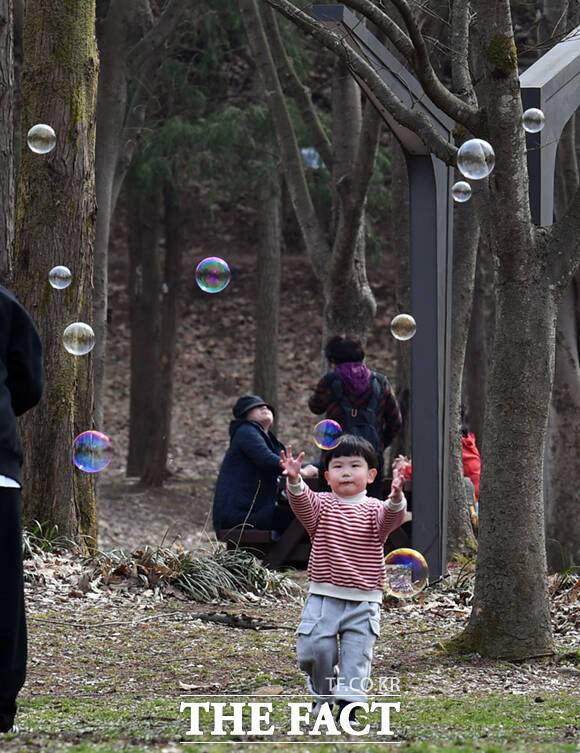 한 어린이가 비눗방울 놀이 삼매경에 빠져 있다.