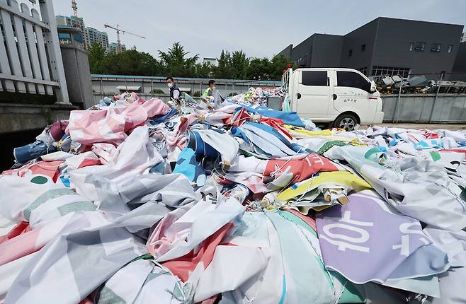 2022년 6월2일 서울 은평구의 한 집하장에서 은평구청 직원들이 철거한 전국동시지방선거 출마 후보자들의 현수막을 트럭에서 내리고 있다. 이 선거에 게시된 현수막은 12만8천여 장, 길이로는 1281㎞에 달했다. 연합뉴스