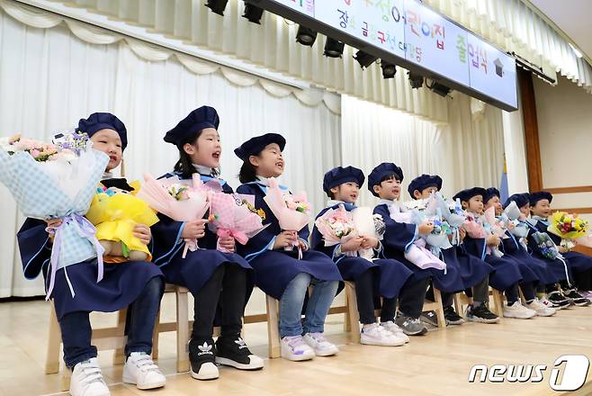 학사모를 쓴 어린이집 어린이들이 꽃다발을 들고 기념 촬영을 하고 있다. /뉴스1 ⓒ News1 윤일지 기자