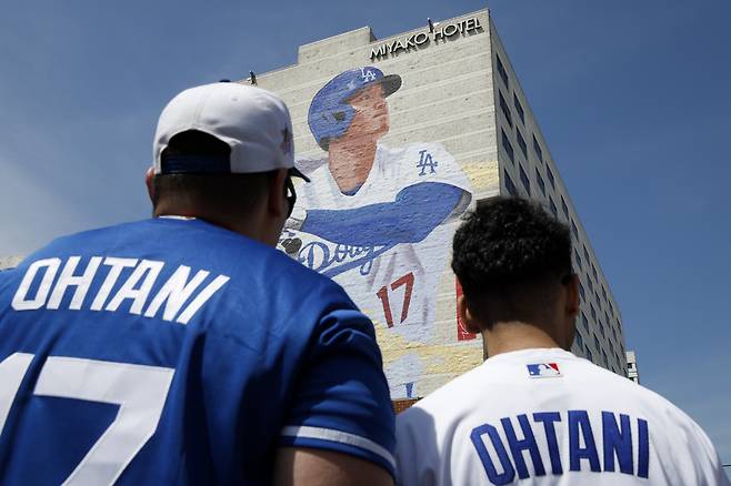 28일(한국시각) LA 시내 한 호텔 벽면에 그려진 오타니의 투타 모습을 담은 대형 벽화를 팬들이 바라보고 있다. EPA연합뉴스