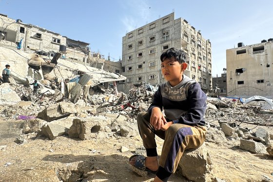 팔레스타인 소년이 이스라엘 공습으로 폐허가 된 가자지구에 앉아있다. 로이터=연합뉴스