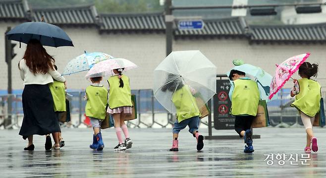 지난해 8월 서울 종로구 광화문광장을 찾은 어린이들이 우산을 쓰고 걸어가고 있다. 서성일 선임기자