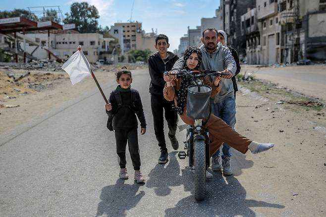 25일(현지시간) 팔레스타인 가자지구 북부 가자시티에서 한 가족이 백기를 들고 피란을 떠나고 있다. AFP연합뉴스
