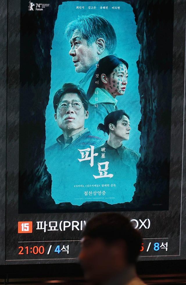 지난 24일 관객 1,000만 명을 돌파한 영화 '파묘'의 상영 시간표 옆을 관객이 지나가고 있다. 연합뉴스