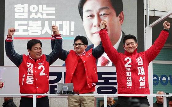 한동훈 국민의힘 비상대책위원장(가운데)이 28일 오후 서울 도봉구 홈플러스 방학점 앞에서 열린 ‘국민의힘으로 도봉 살리기’ 지원유세에 참여해 도봉갑 김재섭(오른쪽), 도봉을 김선동 후보와 함께 손을 들어 인사하고 있다. [뉴시스]