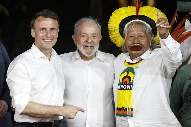 에마뉘엘 마크롱 프랑스 대통령(왼쪽)과 루이스 이나시우 룰라 다시우바 브라질 대통령(가운데)이 26일(현지시간) 브라질 아마존 파라주의 벨렝의 한 섬에서 원주민과 만나 사진을 찍고있다. EPA연합뉴스