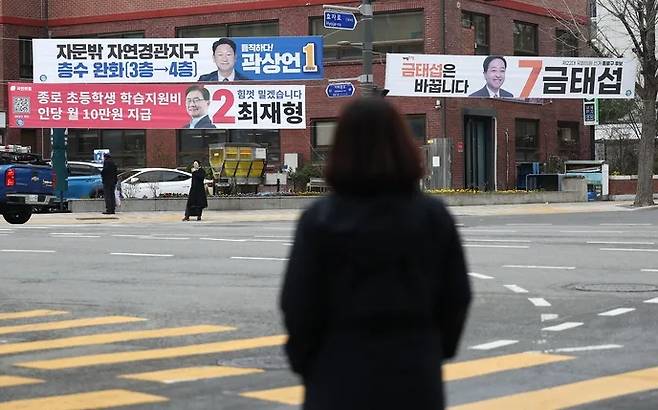 A citizen looks at promotional banners of candidates hanging in front of the Cheongwoon Hyo-dong resident center in Jongno, Seoul, on Monday, as the official campaigning for the 22nd National Assembly election began. Yonhap News Agency