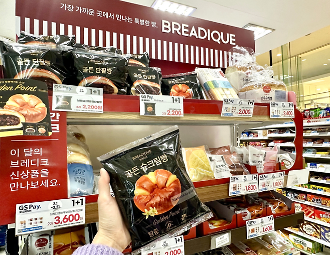 고객이 GS25 프리미엄 베이커리 ‘브레디크’의 골든 슈크림빵을 고르고 있다. [사진 출처 = GS25]
