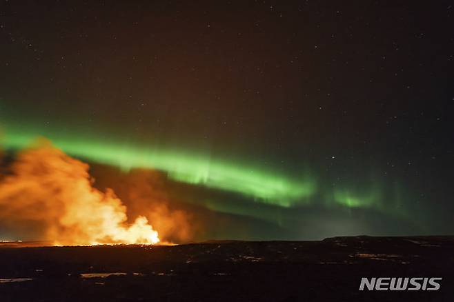 [레이캬비크=AP/뉴시스] 28일(현지시각) 아이슬란드 남서부 레이캬비크 반도 그린다비크 화산이 분화하는 동안 인근 상공에 북극광(오로라)이 펼쳐지고 있다. 2024.03.29.