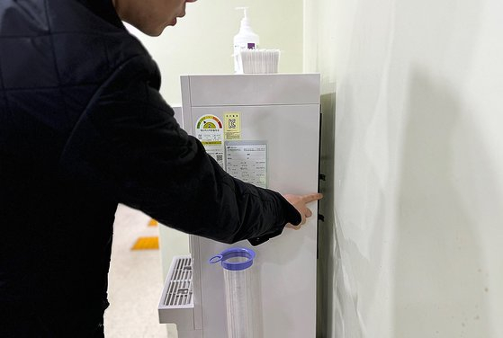 A person points behind a water dispenser at an early voting site for the April 10 general election in Namdong District, Incheon, to explain where a spy camera was hidden. [NEWS1]