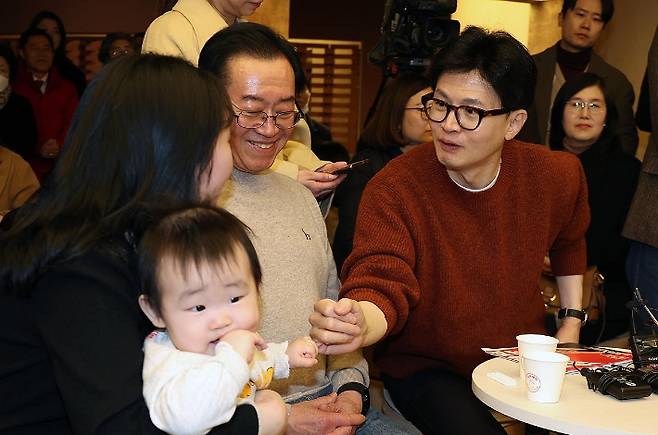 국민의힘 한동훈 비상대책위원장이 지난 5일 충북 청주시에서 진행된 육아맘들과 간담회에서 한 참석자의 아기를 안아주고 있다. 연합뉴스