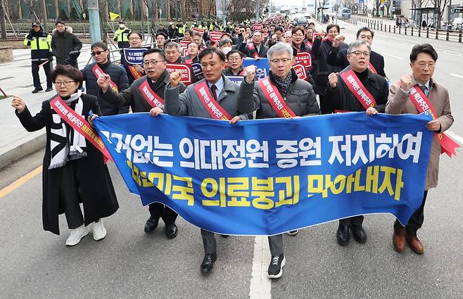 25일 오후 서울 용산구 대한의사협회에서 열린 '전국 의사 대표자 확대 회의 및 행진 행사'에서 참가자들이 대통령실 방향으로 행진하며 의대 정원 증원 반대 구호를 외치고 있다. /연합뉴스