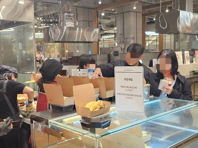 28일 서울 대형 백화점 식품 코너에서 떡볶이 1팩과 튀김 1팩을 1만원에 할인 판매하고 있다. 코너 앞에는 손님 두 명이 떡볶이 세트를 구매하고 있다. /조연우 기자