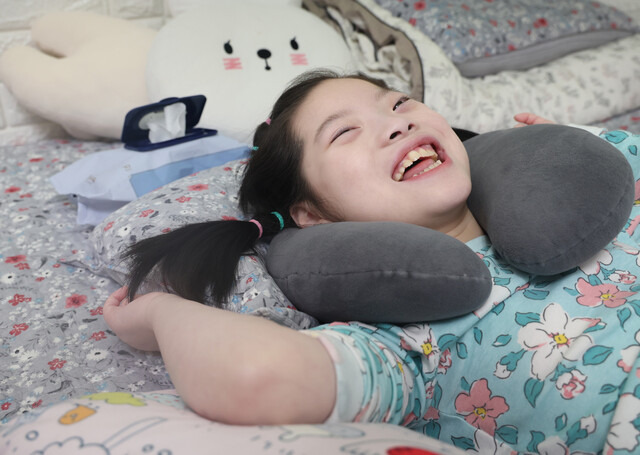 뇌병변과 레트증후군을 앓고 있는 안서연(가명·10)이 지난 25일 오후 경기 고양시에 있는 집에서 위루관을 통해 물을 마시며 웃고 있다. 서연이는 사람들의 말소리가 들릴 때마다 재미있다는 듯이 웃음을 터트렸다. 김영원 기자 forever@hani.co.kr 김영원 기자 forever@hani.co.kr