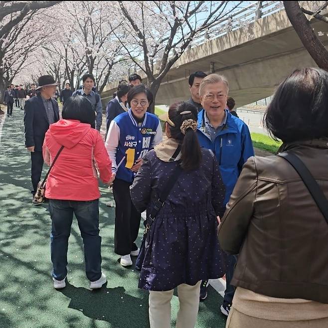 문재인 전 대통령이 1일 배재정 더불어민주당 후보를 격려하기 위해 부산 사상구를 깜짝 방문했다. 문 전 대통령은 배 후보와 부산 사상구 괘법동에 있는 낙동강 벚꽃길에서 시민들과 인사를 나누고 있다. 연합뉴스