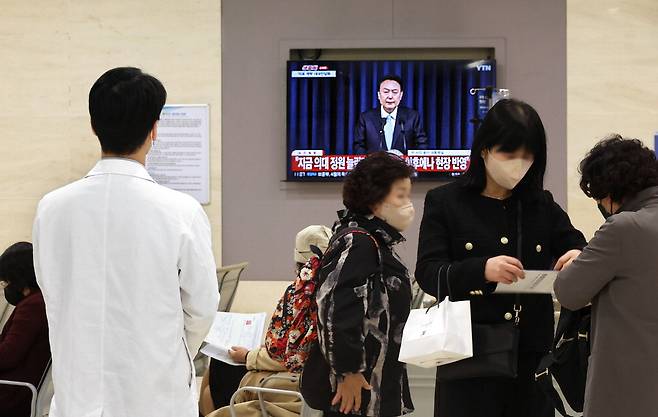 1일 서울의 한 대형병원에서 하얀 가운을 입은 의료인이 윤석열 대통령의 의대 증원과 관련한 대국민 담화를 TV 생중계로 지켜보고 있다. 
 이충우 기자