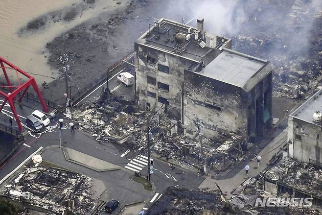 [와지마=AP/뉴시스]일본 이시카와현 노토반도에서 지진이 일어난 지 1일로 3개월이 된 가운데, 여전히 집에 돌아가지 못하고 피난 생활을 하는 이재민이 8000명을 넘는 것으로 알려졌다. 지난 1월3일 일본 이시카와현 와지마의 지진으로 타버린 건물에서 연기가 피어오르고 있다. 2024.04.01.