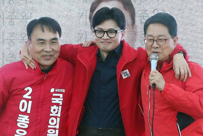 국민의힘 한동훈 비상대책위원장(가운데)이 1일 오후 경남 창원시 진해구 중원로터리에서 이종욱 후보(경남 창원-진해·왼쪽), 총선 
불출마를 선언한 이달곤 의원과 어깨동무를 한 뒤 지지를 호소하고 있다. 한 위원장은 이날 “부가가치세 간이과세자 적용 기준을 연 
매출 8000만 원에서 2억 원으로 상향 조정하겠다”고 공약했다. 창원=뉴스1