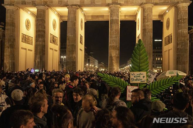 [베를린=AP/뉴시스] 1일(현지시각) 독일 베를린에서 '스모크 인' 행사가 열려 브란덴부르크 게이트 앞에 모인 사람들이 마리화나를 피우고 있다. 독일 정부가 1일부터 대마초를 부분 합법화해 18세 이상 성인은 최대 25g의 대마초를 소지할 수 있게 됐다. 2024.04.02.