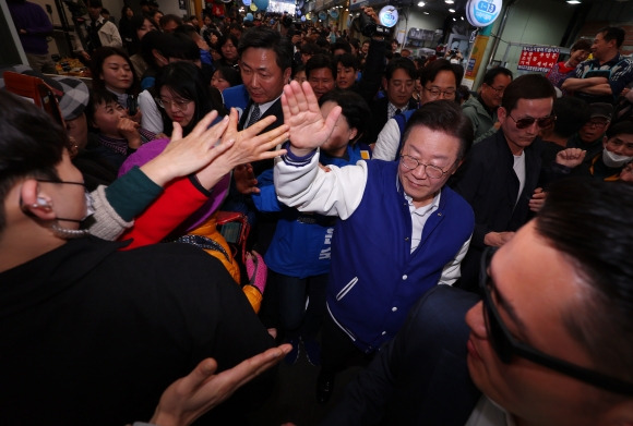 이재명 더불어민주당 대표가 지난달 15일 부산 부산진구 당감시장을 찾아 경호를 받으며 지지를 호소하고 있다. 연합뉴스