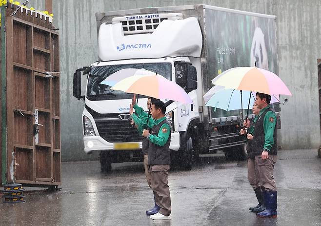 3일 오전 경기도 용인시 에버랜드에서 강철원 사육사 등 사육사들이 중국으로 떠나는 푸바오를 싣고 있는 무진동 특수 차량 앞에서 내빈들에게 인사하고 있다. [연합]