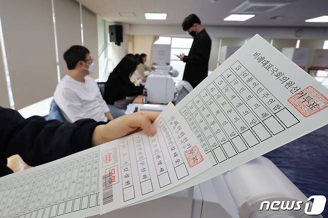 4일 오후 서울 용산구 이촌1동 사전투표소에서 관계자들이 모의투표를 하며 투표용지를 살펴보고 있다. 2024.4.4/뉴스1 ⓒ News1 이동해 기자