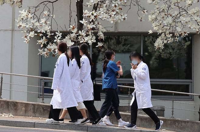 4일 서울 한 대학병원에서 의료진이 흐드러지게 핀 목련꽃 아래를 지나가고 있다. 이날 서울 용산 대통령실에서 윤석열 대통령과 박단 대한전공의협의회 비상대책위원장의 만남이 이루어졌다.  연합뉴스