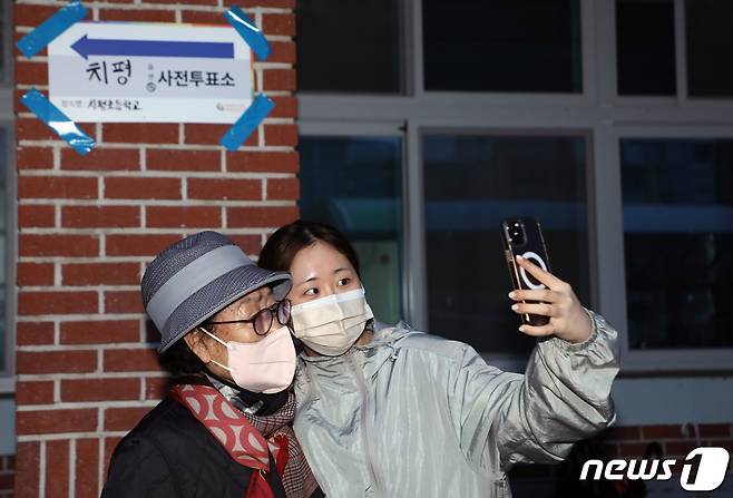 제22대 국회의원선거 사전투표가 시작된 5일 광주 서구 치평동 치평초등학교 투표소에서 첫 투표를 마친 박지효 양(19)과 김정자 할머니(83)가 인증샷을 찍고 있다. 2024.4.5/뉴스1 ⓒ News1 이수민 기자