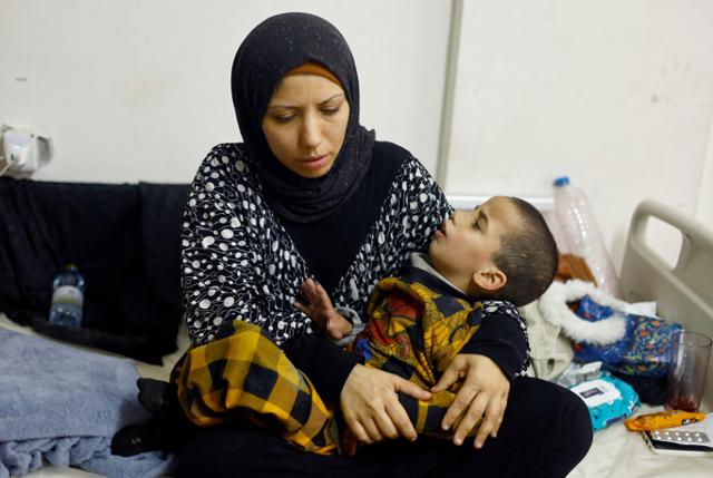 1일 가자지구 남부 라파의 보건소에서 영양실조로 치료를 받고 있는 한 어린이가 엄마의 품에 안겨 있다. 라파=로이터 연합뉴스