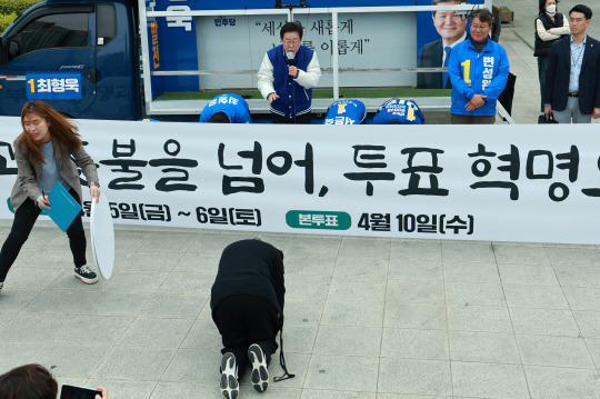 이재명 더불어민주당 대표가 4일 오전 부산 동구 부산역 광장에서 열린 부산시당 국회의원 후보자 사전투표독려 퍼포먼스에 앞서 한 시민이 큰절을 하려고 하자 만류하고 있다. 연합뉴스