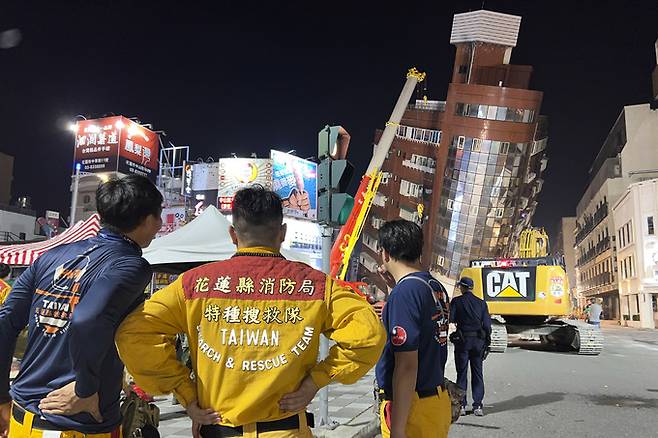 지난 3일 대만 동부 지역에서 발생한 규모 7.4 강진의 영향으로 심하게 기울어진 화롄 시내 건물을 구조대원들이 쳐다보고 있다. AP연합뉴스