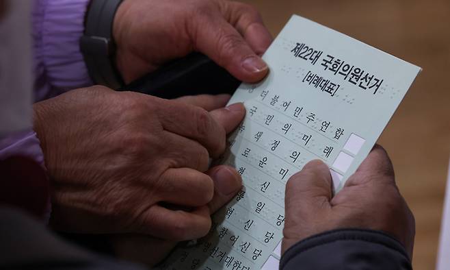 제22대 국회의원선거 사전투표 첫 날인 5일 서울 성동구 왕십리 도선동 공공복합청사에 마련된 사전투표소를 찾은 한 시각장애인이 점자 투표지를 읽고 있다. 뉴시스