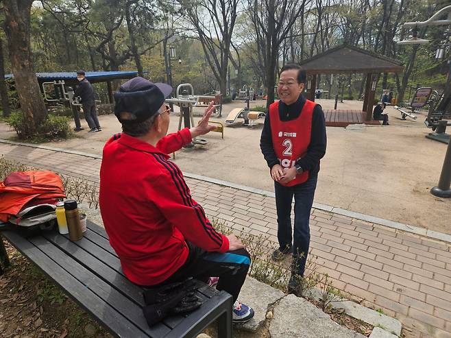 6일 오전 서울 용산 선거구의 국민의힘 권영세 후보가 용산구 효창공원 안에서 한 시민과 인사를 나누고 있다. /권순완 기자