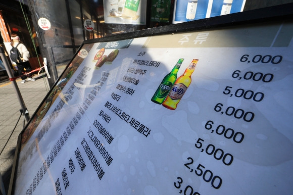 외식 맥주물가 1998년 이후 최고치 - 지난해 식당 등 외식업체에서 판매하는 맥주와 소주 물가 상승률이 대형마트·편의점 판매가 오름폭의 약 3배에 달한 것으로 나타났다. 지난해 식당 등에서 판매하는 외식 맥주 소비자물가지수는 114.66으로 전년 대비 6.9% 올랐다. 이는 국제통화기금(IMF) 외환위기 당시인 1998년 9.7% 이후 25년 만의 최고치다. 대형마트·편의점 등에서 판매하는 가공식품 맥주 물가 상승률 2.4%와 비교하면 2.9배에 달한다. 지난해 외식 소주 물가 상승률은 7.3%로 일반 가공식품 소주 물가 상승률 2.6%의 2.8배에 이른다. 사진은 서울 서초구의 한 식당 메뉴판. 2024. 1. 23. 연합뉴스