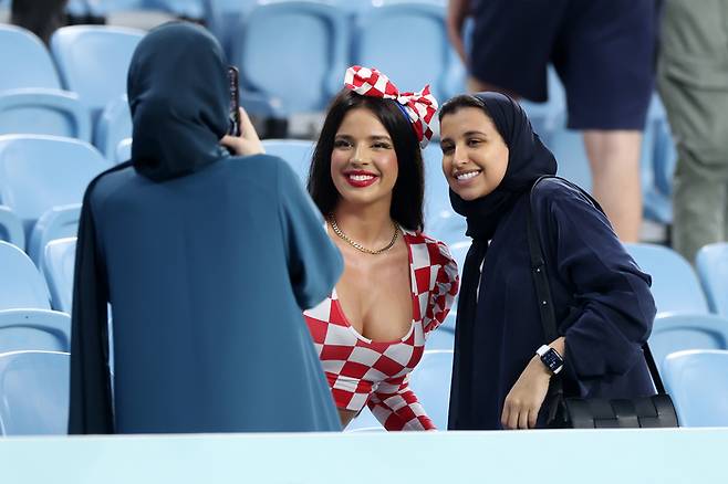 크로아티아 출신의 모델 이바나 놀(가운데)이 2022년 12월 5일 카타르 도하에서 열린 카타르 월드컵 일본과 16강전에서 여성팬의 요청으로 기념 사진을 촬영하고 있다. 게티이미지코리아 제공