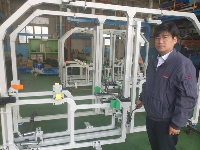 강희찬 금강오토텍 대표가 인천 남구 도화동에 위치한 공장 내 설비 앞에서 포즈를 취하고 있다. 임명수 기자
