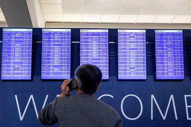 지난해 1월 미국 조지아주 애틀랜타 국제공항(하츠필드 잭슨)에서 한 탑승객이 출입국편을 안내하는 전광판을 확인하고 있다. /로이터 연합뉴스