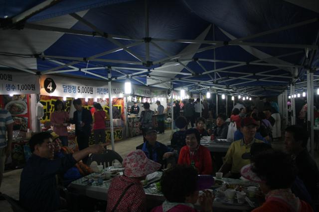 지역 한 축제를 찾은 시민들이 먹거리 부스에서 산 음식을 먹고 있다. 한국일보 자료사진