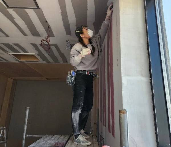 페인트공 최인라씨가 벽 표면을 만지면서 결함을 확인하는 모습. 최씨 제공