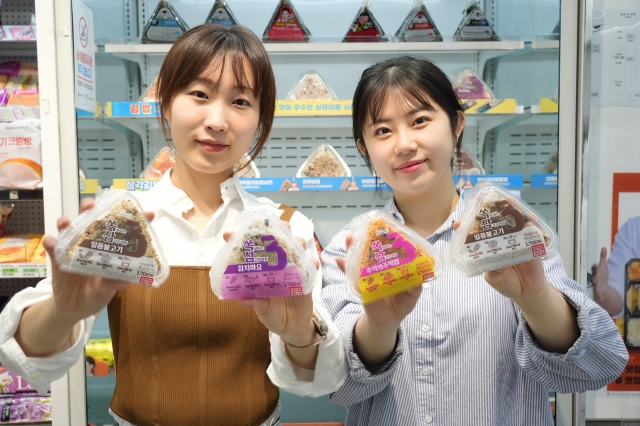모델들이 서울의 한 세븐일레븐 매장에서 하드 케이스에 담겨 휴대가 간편한 삼각김밥 신상품인 '쏙삼'을 들어보이고 있다. 세븐일레븐 제공