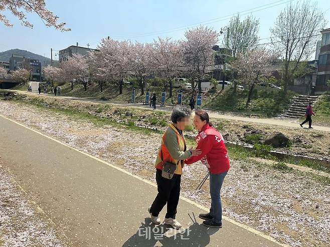 '충남 정치 1번지' 천안갑 지역구에 출마하는 신범철 국민의힘 후보 배우자 정혜진(51)씨가 9일 원성천 일대 쓰레기를 수거하던 중 시민에게 인사하고 있다. ⓒ데일리안 강현태 기자